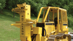 To slice towering trees, arm dozers with a versatile saw attachment