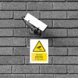 A video surveillance camera and sign warning about CCTV being in operation
